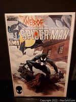 Front cover photo of Web of Spider-Man Comic #1 showing Spider-Man in a black suit crouching on a gargoyle statue with a building and moon in the background.