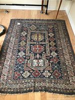 Full view of the Turco-Persian style rug showing geometric medallions and floral motifs with color palette of dark blue, red, beige and light blue.