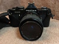 Front view of Pentax MX camera with attached macro focusing zoom lens showing lens cover.