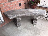 Full side view of curved bench showing seat surface and two pedestal supports