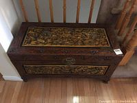 Front view of wooden chest with carved dragon panel and metal latch