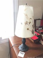16-inch Dornbush table lamp on wooden surface with visible floral lampshade and metal sculpted base.