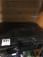 Black plastic carrying case with Dremel branding embossed on top, closed.