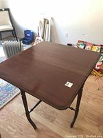 Side view showing one leaf up and one folded down, unique shaped turned legs with horizontal supports.