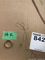 Overview showing wedding band, broken fine chain and two-tone box chain