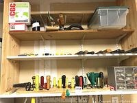 Wide view of shelves with assortment of screwdrivers, scissors, containers, and small drawers with hardware.