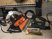 Photo of Black & Decker Skilsaw 7.25 circular saw, Black & Decker Quantum jigsaw with extra blades in front of it, on floor