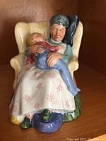 Front view of Royal Doulton 'Sweet Dreams' figurine showing woman holding sleeping child in armchair.