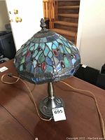 Front angle photo of stained glass lamp showing multi-colored glass and metal base.
