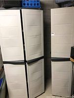 Pair of closed plastic storage cabinets with black handles shown from the front.