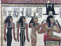 Close-up view of hand-painted Egyptian figures and hieroglyphics on papyrus.