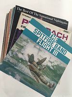 Stack of vinyl LP records showing covers including The Spitfire Band Flight III and The Best of The Sensational Nightingales