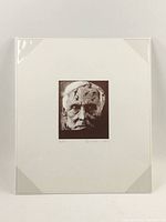 Frontal photo of a black and white portrait print of Max Ernst's face with a surreal textured overlay, mounted on a white background.