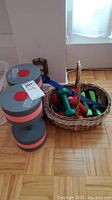 Full view showing two large foam water dumbbells and a basket with smaller weights and accessories