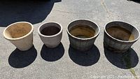 Top-down and side view showing all four planters in a row on asphalt, highlights size variations and materials.
