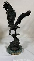 Front view of full bronze eagle sculpture on marble base