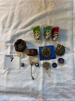 Overview of entire pin and accessory collection laid out on white cloth.