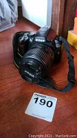 Front and side view of Nikon D40x camera with attached lens and Nikon lens cap, showing condition and markings.