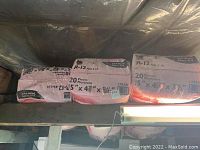 Photo showing three bags of R-12 fiberglass insulation batts in pink packaging with dimensions 15 x 4 x 49 inches, 20 pieces each.