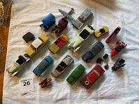 Top and angled view showing all toy cars and vehicles spread on white cloth, varied colors and sizes.