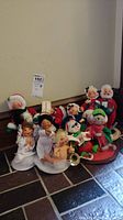 Full group of eleven assorted Annalee Christmas figures arranged on floor, includes angels, mice, Santa, Mrs. Claus, and Christmas characters.
