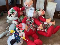 Group photo showing most of the six AnnaLee Christmas dolls arranged on carpeted floor with furniture background
