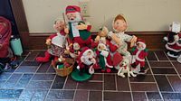 Photo showing a group of twelve Annalee Christmas themed dolls including Santa, Mrs. Claus, children, and a dog.