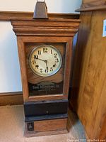 Full front view of oak case, metal dial and base