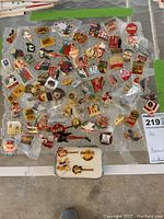 Overhead photo showing more than 75 pins arranged on bubble wrap, featuring many Coca-Cola pins and others from various brands