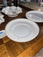 Overview of different Silver Crest glass pieces on wooden table including ruffled edge pie dishes and ruffled edge holders
