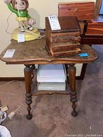 Front view of the quartersawn oak wooden side table showing the tabletop and turned legs with decorative circular elements.
