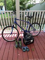 Full lot overview showing bicycle, helmet, roller skates, and cable locks