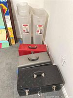 Three metal toolboxes in red, silver, and black colors arranged on the floor, showing condition and style.