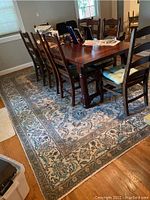 View of the full rug under dining table showing size and design in room context.