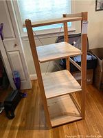 Full view of the IKEA HEJNE wooden shelf showing three shelves, with back railing on top shelf and vertical supports on sides.