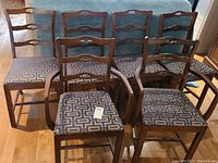 Set of six wooden chairs, four without arms, two with arms, all with upholstered seats and medium brown wood finish