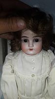 Close-up of the doll's head and upper torso, showing facial features and dress details.
