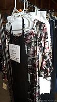 Floral patterned dress, black dress, and white pants hung on hangers