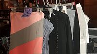 Assorted women's size 12 clothes on hangers including bathing suit, tops, and pants