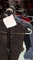 Closet rod with multiple women's clothes on hangers with a sign reading 'XL Clothes'
