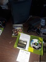 Xbox 360 console with 120GB hard drive visible next to Call of Duty 3 game case and wireless controller on a table.