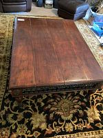 Top-down view of the coffee table top showing wood grain, scratches, and metal rivet details at the edges