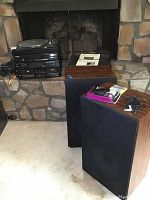 Photo showing the entire stereo system setup, including two tall MCS speakers, electronic components stacked on a rack, and cables.