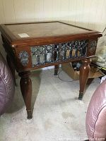 Full view of the wooden end table showing stone-like top surface, turned legs and metal insets on sides.