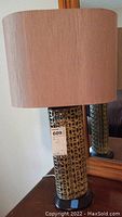Front view of ceramic base and oval beige linen shade on lamp