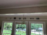 Seven Sheila houses displayed on a shelf above windows in a room, showing scale and arrangement.