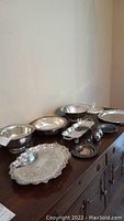 Full set including 3 platters, 3 bowls, 2 small servers, salt and pepper shakers, and pewter bowl displayed on wood surface