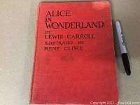 Front cover of the red hardcover book showing title, author Lewis Carroll and illustrator Rene Cloke.