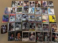 Wide shot of 38 vintage Wayne Gretzky hockey cards laid out on table showing various designs and teams