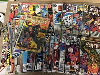 Overhead shot of approximately 20 Marvel comics in plastic sleeves, front covers visible